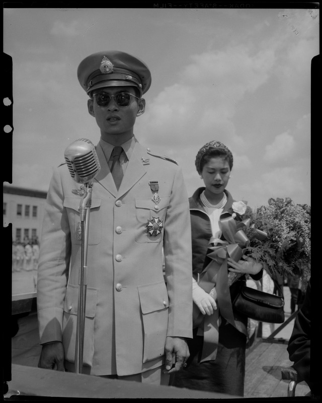 King Bhumibol Adulyadej of Thailand addressing crowd with the Queen Sirikit behind him