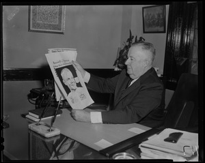 Man sitting with copy of the Record American Glenn Orbit Picture Book