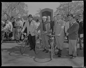 Melvin J. Gordon, Dr. Paul Dudley White and Dr. Shane MacCarthy standing with their bikes as spectators look on