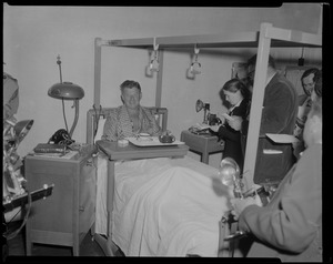 Arthur Godfrey in bed, surrounded by reporters and photographers