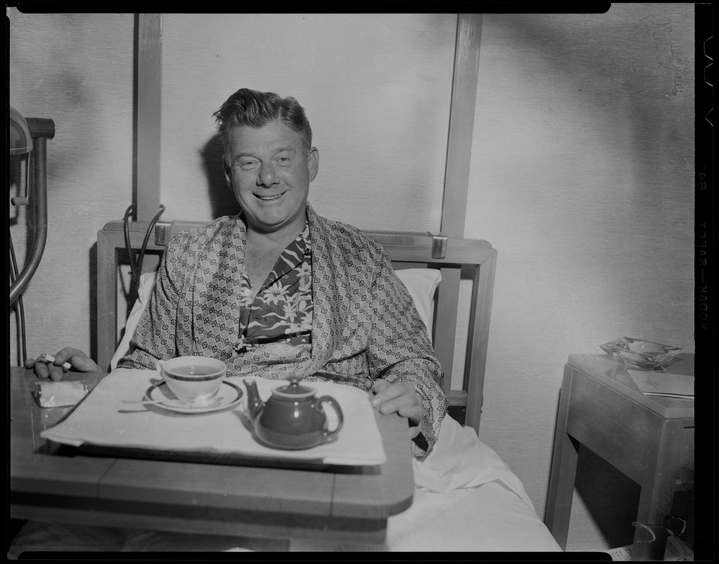 Arthur Godfrey sitting in bed with tray of tea