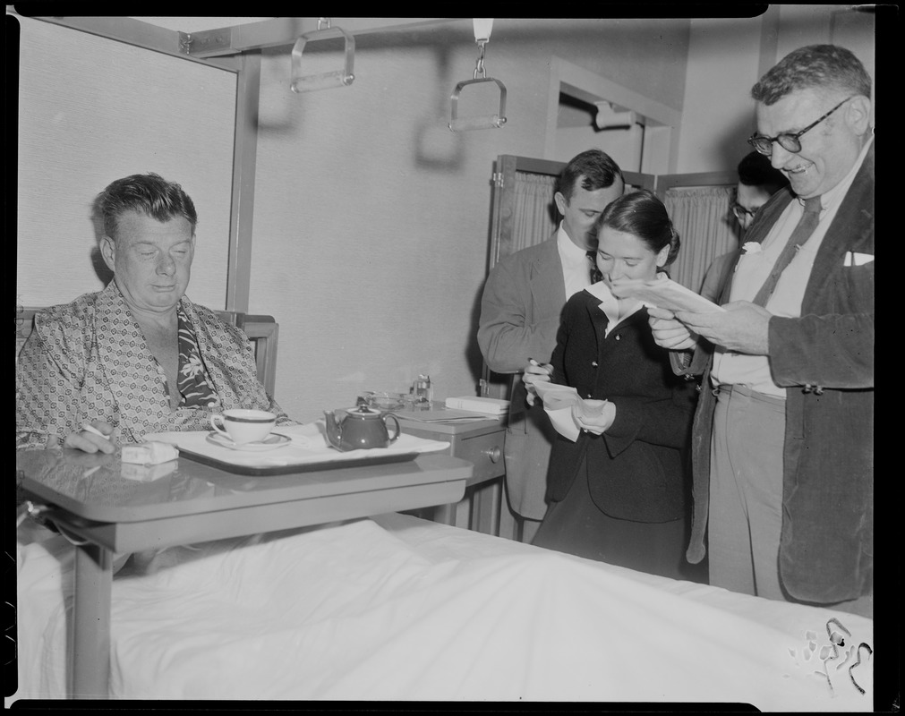 Arthur Godfrey in bed with a group at his bedside