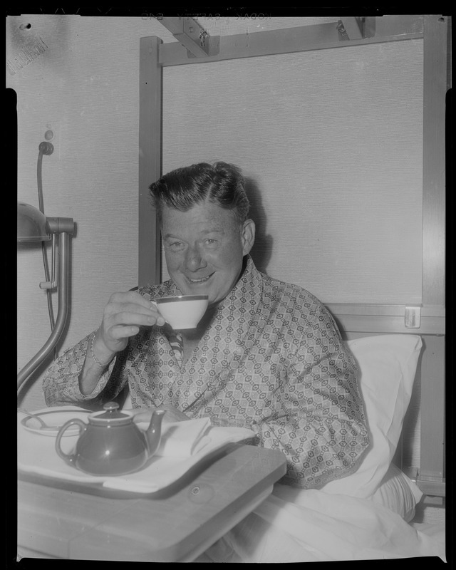 Arthur Godfrey in bed holding a tea cup