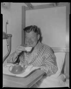 Arthur Godfrey in bed holding a tea cup