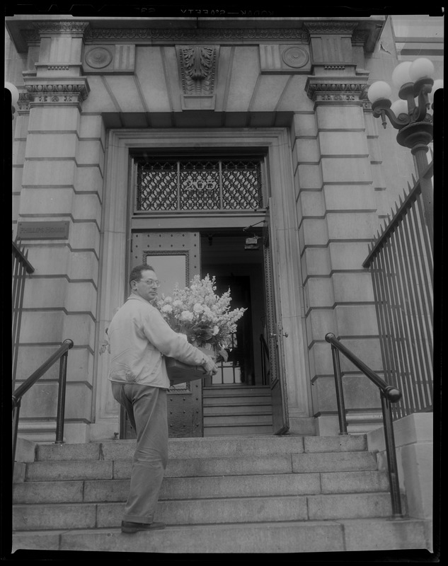 Man carrying large floral arrangement