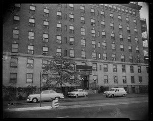 Building exterior with vehicles parked on street