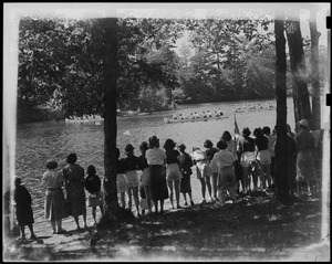 Spectators on the riverbank watching canoe race