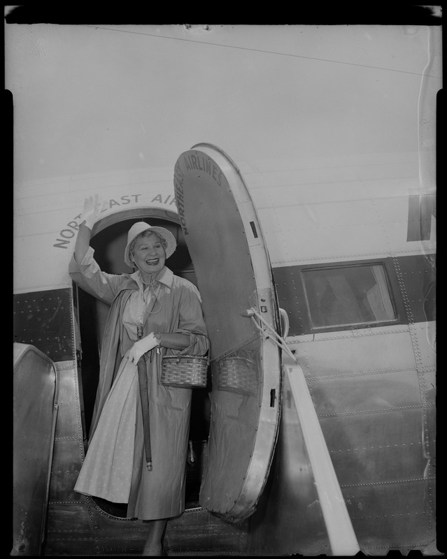 Shirley Booth waving from the top of the airplane staircase