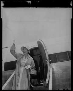 Shirley Booth waving from the top of the airplane staircase