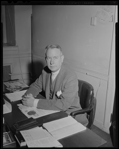 James W. Austin seated at desk
