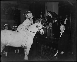 Chief White Horse of the Mashpee Indians, atop a white horse, presents a bouquet to Mary Curley, daughter of Governor James Michael Curley