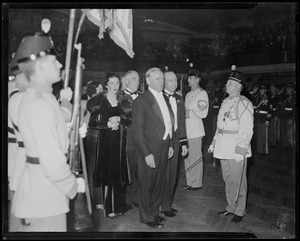 Governor James Michael Curley, General William I. Rose, Mary Curley and others stand in procession surrounded by uniformed military men