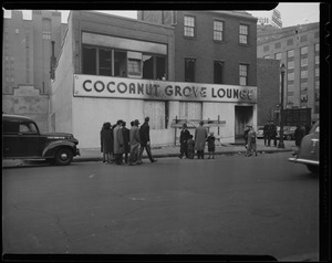 Onlookers in front of boarded up entrance to Cocoanut Grove