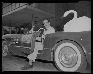 Nelson Bragg in a WBZ-TV convertible with a large swan and "Swan Boat" written on the driver-side door