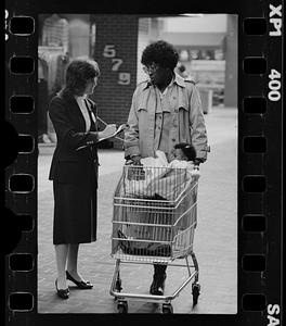 Market researcher interviews customers at shopping mall in Brighton