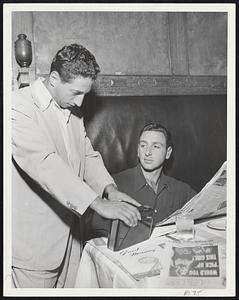 Checking Yanks-Indians Score with help of their portable radio while lunching at Kenmore yesterday are Chicago pitchers Marv Rotblatt (left) and Saul Rogovin. Chisox opened important series with Red Sox at Fenway Park last night.