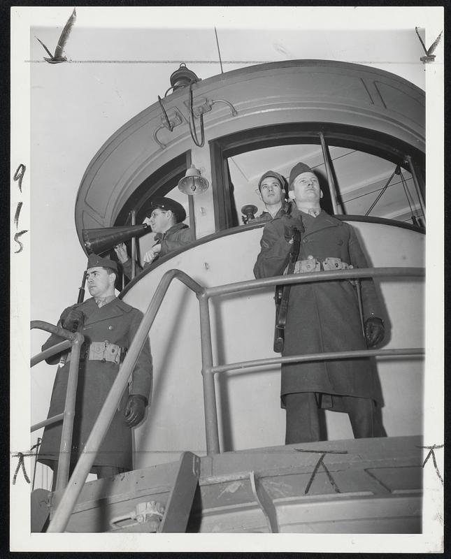 Marines Guard Navy Tug At Brooklyn -- Two armed Marines stand guard in front of pilot house on the Navy tug Manatee at the Brooklyn Navy Yard as Chief Boatswain's Mate R.C.A. Bangs of Milford, Ct. (with megaphone), directs tug's operations, assisted by Seaman 1/c Albert Ahearn of Boston. A strike of civilian tugboat men is in progress in the harbor.