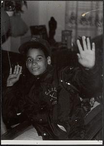 Young man wearing baseball hat and holding up his hands