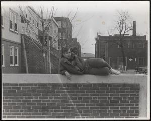Nikki lounging on a brick wall