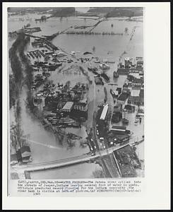 Water Problem--The Patoka River spilled into the streets of Jasper, Indiana leaving several foot of water in spots. Officials predicted record flooding for the Indiana community. The river bank is visible at left of picture.