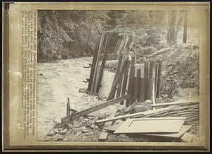 Flood Damage--Concrete forms and structural steel were twisted and jammed at site of new Main street bridge in Meriden Tuesday, when Blood's Brook went on a rampage from four hours of torrential rain. A foot bridge installed at the site during construction was also swept away.