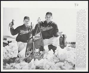 Baseball Shoes or Snowshoes? - Rookie infielder Bernie Allen (left), and home run slugger Harmon Killebrew, of the Minnesota Twins, hold up their baseball shoes and a pair of snowshoes while posing atop a big pile of snow today at the Metropolitan Stadium is Twin Cities. The Twins were scheduled to meer Los Angeles today in their American League home opener, but the game was called off because of snow. Almost six inches of snow fell yesterday. The Twins are working out indoors today.