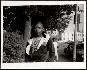 Young man posing on sidewalk