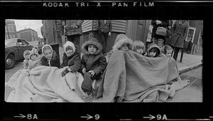 Kids keep warm under a curbside blanket at St. Patrick's Day Parade, Boston