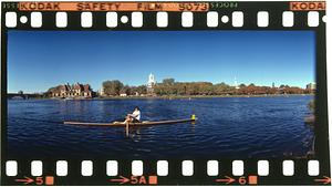 Single sculler on Charles River across from Dunster House at Harvard, Boston