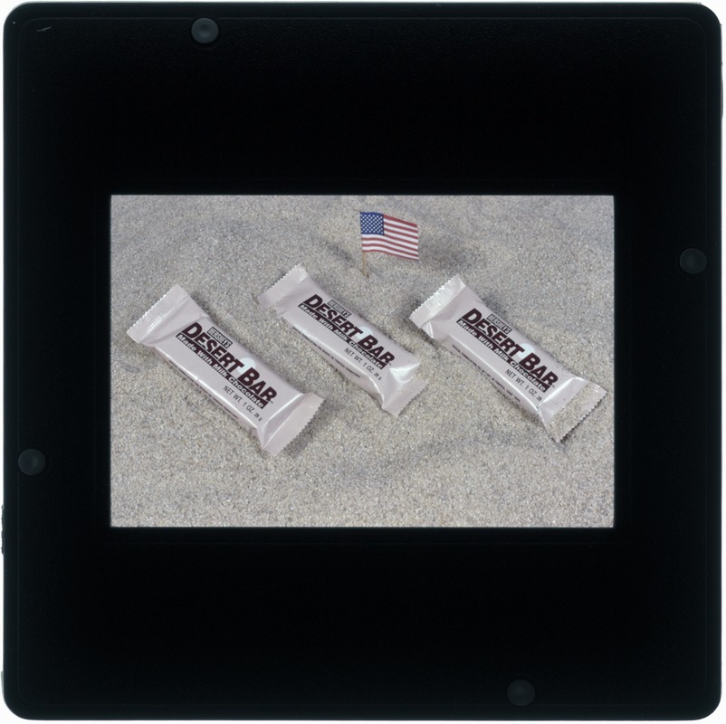 Food lab, desert shield, candy bar on sand with flag