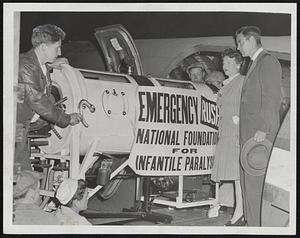 Respirators for Stricken Children of the West were flown from Boston last night by local representatives of the National Foundation for infantile Paralysis. One is shown being loaded aboard on Army plane at Boston airport under the direction of Joseph Nee, former Harvard Football player and representative of the foundation, and Kay Jobert, executive secretary of the Norfolk County chapter.