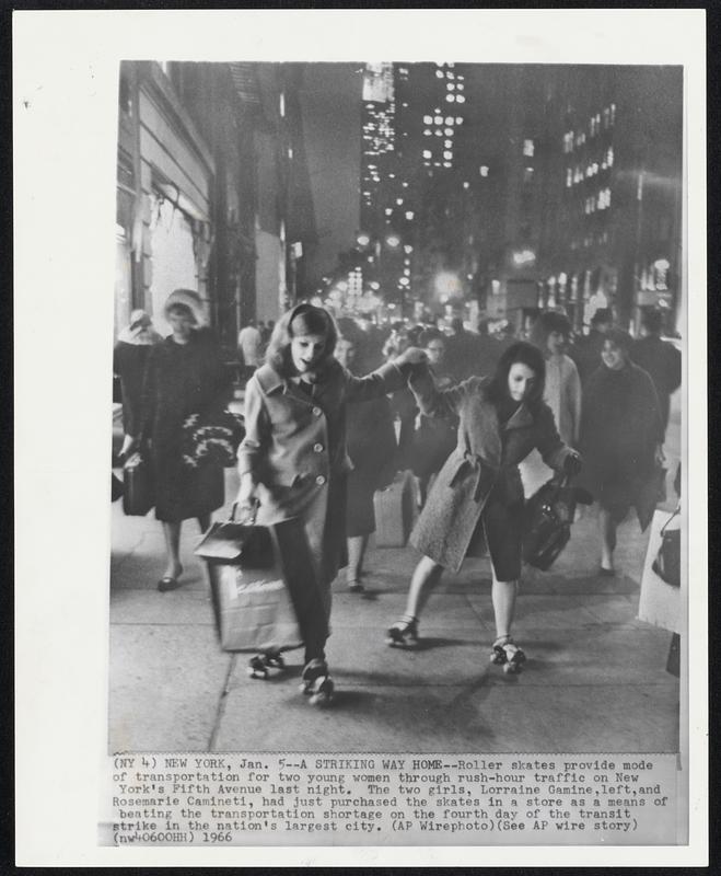 A Striking Way Home -- Roller skates provide mode of transportation for two young women through rush-hour traffic on New York's Fifth Avenue last night. The two girls, Lorraine Gamine, left, and Rosemarie Caminet, had just purchased the skates in a store as a means of beating the transportation shortage on the fourth day of the transit strike in the nation's largest city.