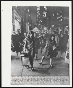 A Striking Way Home -- Roller skates provide mode of transportation for two young women through rush-hour traffic on New York's Fifth Avenue last night. The two girls, Lorraine Gamine, left, and Rosemarie Caminet, had just purchased the skates in a store as a means of beating the transportation shortage on the fourth day of the transit strike in the nation's largest city.