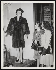 They Needed it Yesterday--Mrs. Marty Alice Pippin, left, of Nashville, Tenn., and Mrs. Clara Johnson of Swainsboro, Ga., visiting Boston, agree that the fur coat in this downtown store window would have come in handy yesterday when temperature dropped from 94 to 61 degrees.
