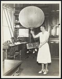 Balloon "Robot" Radios Weather Reports. This is the newest device to be used by the U.S. Weather Bureau in exploring the stratosphere, and it sends down radio reports of temperature and atmospheric pressure as it rises. A photo electric cell translates thermometer and barometer readings into radio signals. The photograph was made in Washington, D.C.