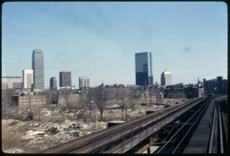 Train tracks heading toward Back Bay, new and old John Hancock building and Prudential Tower in background