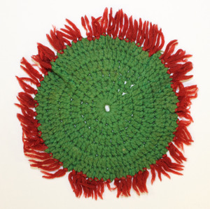 Green doily or caster with red fringe, made by Laura Bridgman