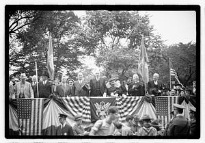 A group of people seated on a reviewing stand including Boston Parks Commissioner William Long