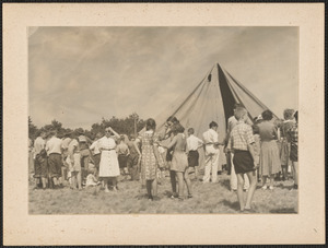 People by tent in field