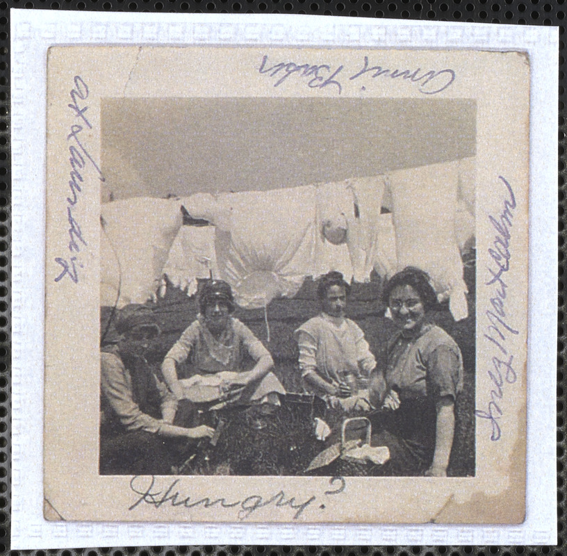 Inez Montcalm, Annie Baker, and friends in front of the Cape Cod Laundry with a picnic basket and a clothesline behind them