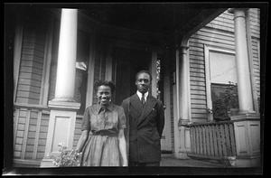 A man and a woman stand in front of porch