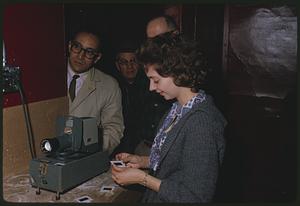 Group gathered around slide projector
