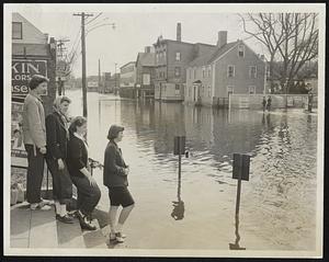 High Water Remained on Foster St., Peabody Sq. long after the flood. Four high school juniors gaze from post office steps, thinking "we sure could use a row boat." Left to right, Nancy Dolan, 15; Ruth Kankalo, Mary Agnes Crowley and Mary Pyburn, all 16.