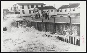 Group of People (top photo) inspect a breakwater taking a lashing from waves at Kure Beach, N. C. This was just before Hurricane Connie moved in.