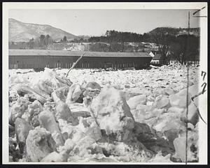 Ice-Jammed River Floods Vermont Countryside- Ice Cakes jammed in the Connecticut river near Windsor, Vt., rolled flood waters over the countryside, blocking highway and rail traffic and isolating the northern half of Windsor. The bridge from Windsor to Cornish, N.H., shows over the miniature icebergs jamming the river.