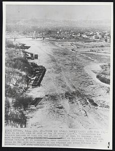 Thick Ice Stalls Barges Laden With Fuel Oil-- This is an air view of most of the 28 barges (left), transporting two million gallons of fuel oil and 28,000 tons of coal to Chicago, which were blocked by an Illinois River ice jam. Ottawa skyline is in background. Army engineers estimated yesterday it would be two more days before an ice breaker can smash through the barrier.