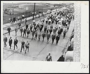 Detroit – UAW Stages Parade – An estimated 5,000 UAW-CIO strikers marched in a parade here yesterday and assembled for a mass meeting at the gates of the Ford Motor Company’s Rouge Plant. UAW President, Walter P. Ruether is second from right in the first line of marchers. The strike at Ford continues into its fifth day.