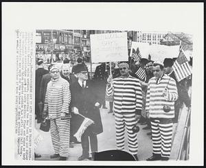 Sympathizers Say it With Stripes in Transit Strike - Philadelphia transit union workers, supporting the New York bus and subway strikers, wear convict-type garo and carry American flags and signs as they join Transport Workers Union pickets outside New York's City Hall today. The demonstration was held for the release of union officers imprisoned last week.