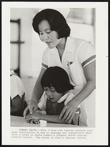 Common Cause--This 7-year-old Leprosy patient gets some instructions on how to massage her insensitive hand from a nurse at Kuala Lumpur's Shunghei Buloh Leprosy Control Center. The nurse is also a leprosy victim.