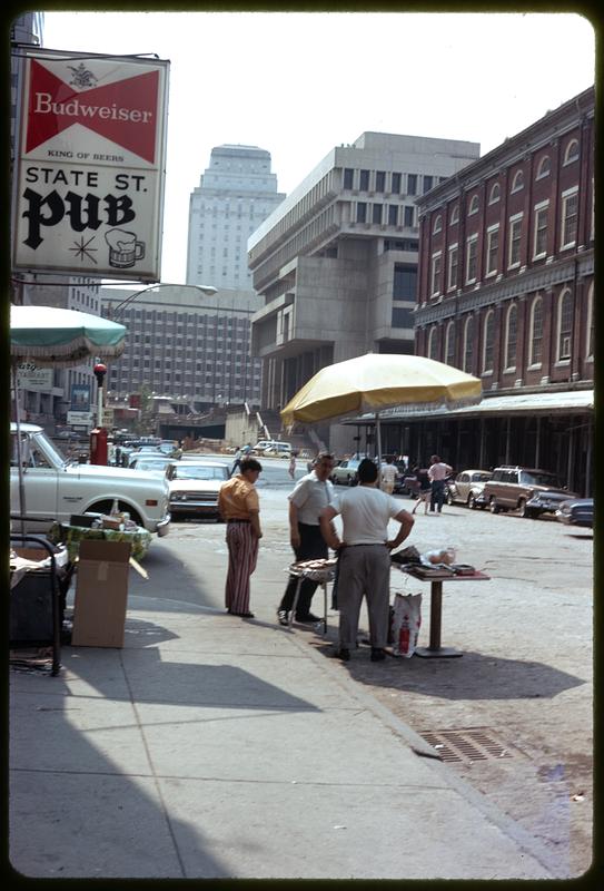 Food vendor in front of State St. Pub, Boston City Hall in background